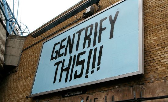 Billboard graffiti reads 'gentrify this' (photo: amanda farah/flickr)