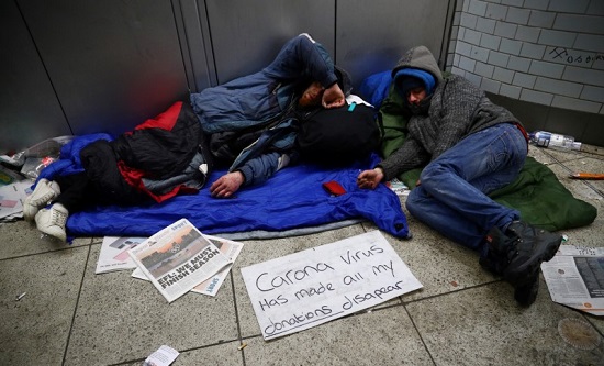 Rough sleepers with a sign 'covid has made all my donations disapear [sic]]