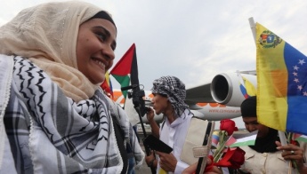 A Palestinian woman is greeted by a crowd upon her arrival in Venezuela AVN