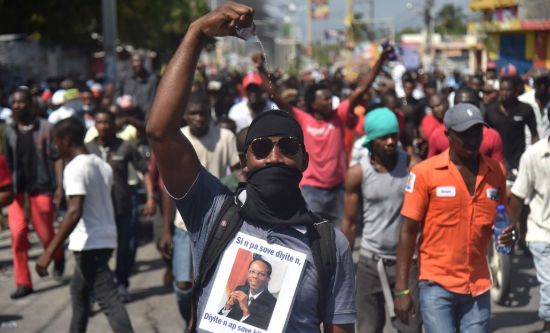 Protester in Haiti with a t-shirt showing Jean-Bertrand Aristide