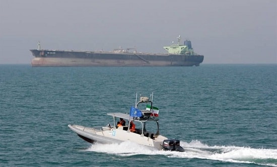 A tanker in the Strait of Hormuz. Foreground: Iranian naval vessel