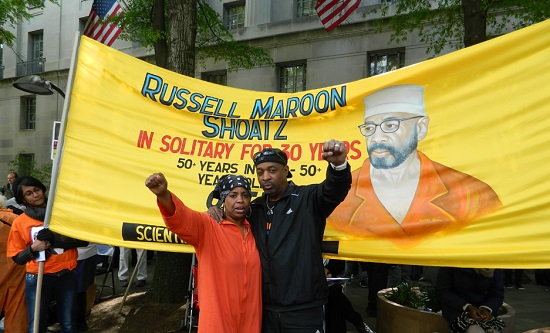 Theresa Shoatz, daughter of Russell “Maroon” Shoats, stands with Chuck D in front of a banner demanding Maroon’s freedom (Photo: Prison Activists Resource Center)