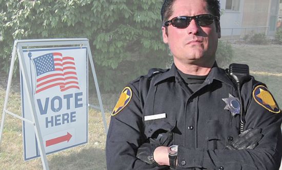 Police cross-armed with polling station sign